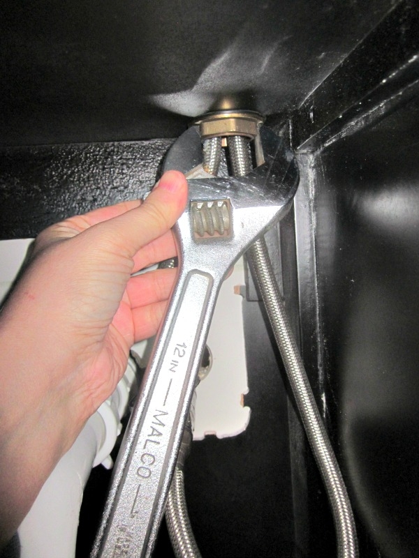 You may not have enough room to hold the wrench straight out from the nut, but you can get enough leverage at another angle (use the handle, though--I'm holding it like this only because I have a camera in the other hand!).